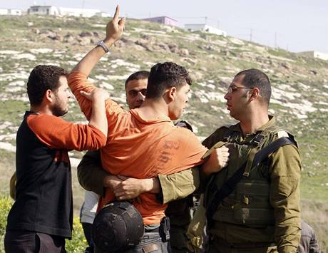 Izraeltí vojáci zadrují po potyce Palestince.